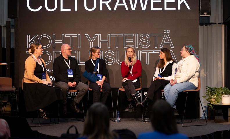 Kuusi panelistia konferenssissa keskustelemassa