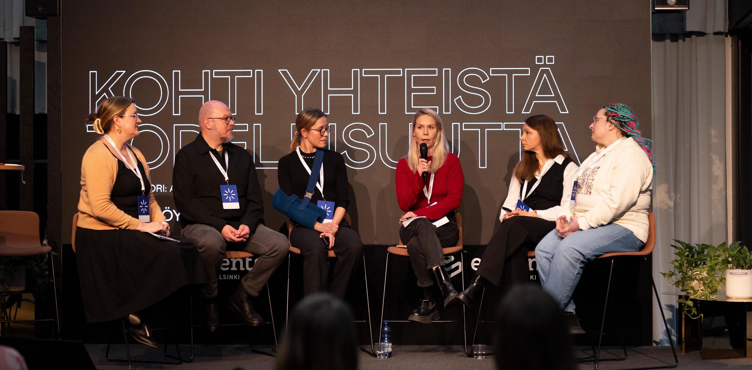 Kuusi panelistia konferenssissa keskustelemassa
