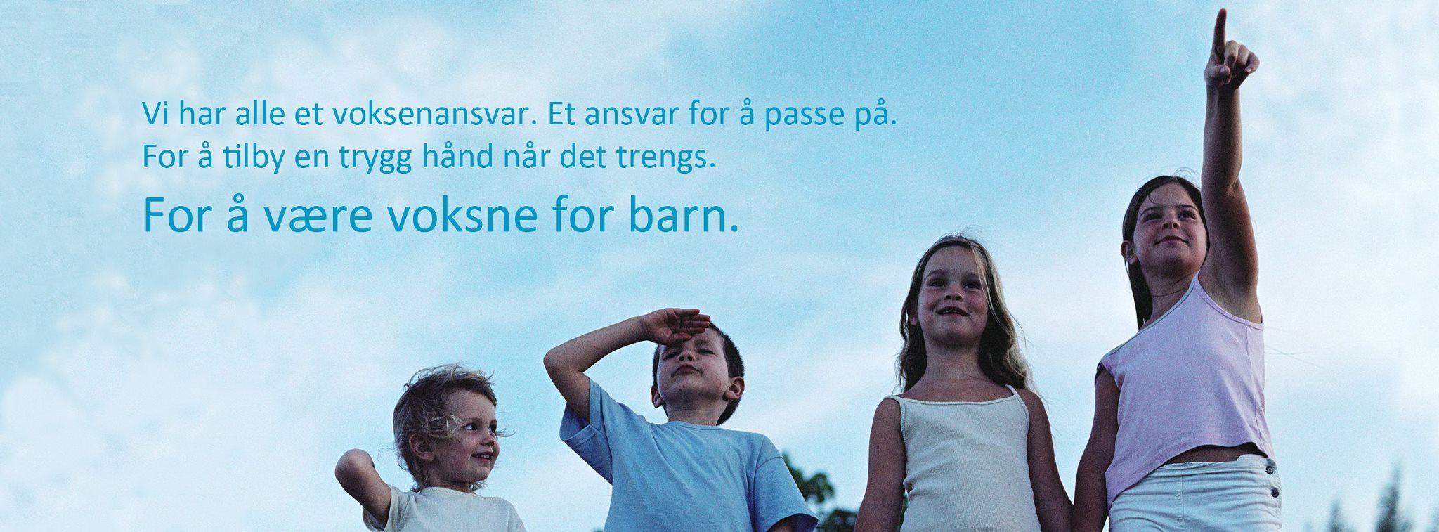 Four happy children stand in a row, gesturing and smiling against a bright sky.