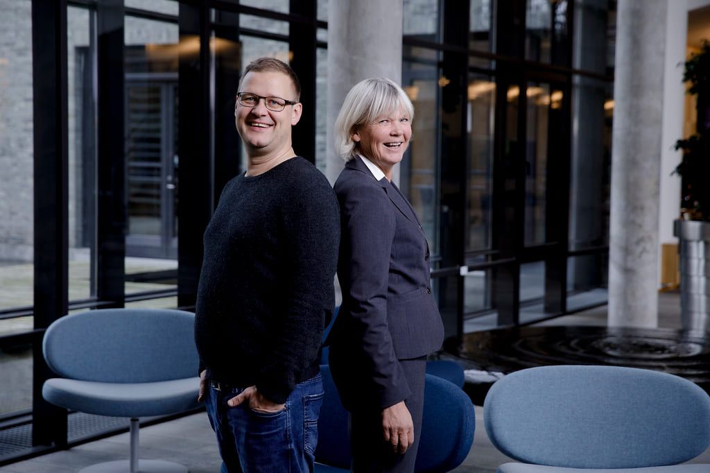 Psykologspesialistene Bjarne Hansen og Gerd Kvale har utviklet en hurtigbehandling av mennesker med angst- og tvangslidelser. Her står de smilende rygg mot rygg, vendt mot fotografen.