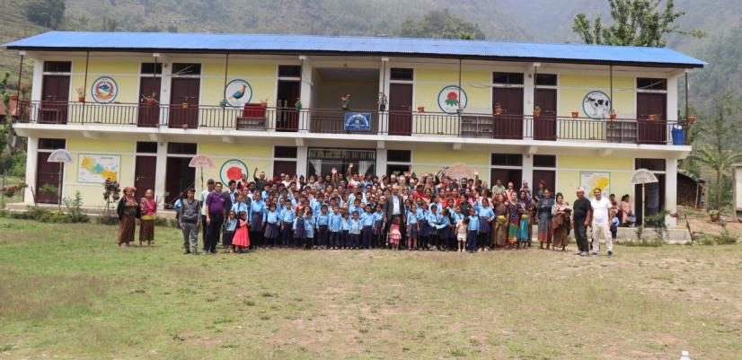 Gruppfoto av elever och lärare framför en skolbyggnad i Taplejung.