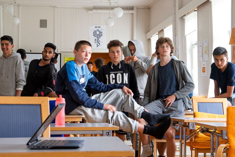 Flere unge gutter henger i klasserommet i en pause. 