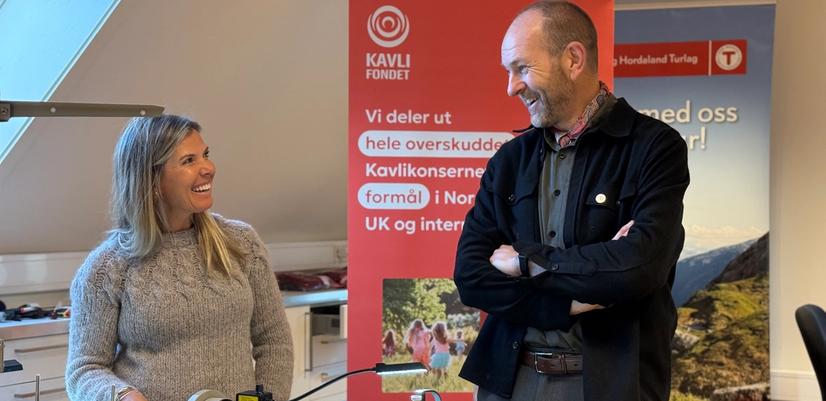 En dame og mann foran en symaskin