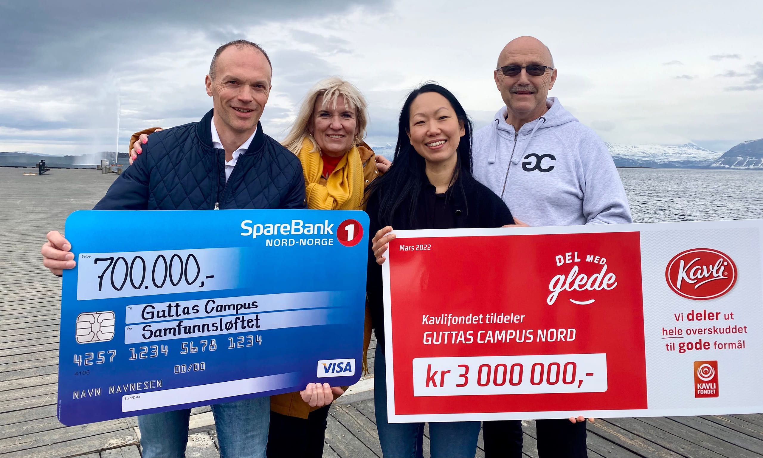 På en brygge i Harstad står representanter for spleiselaget sammen med daglig leder i Guttas Campus og holder oppe gavesjekkene.