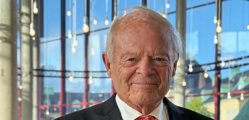 Mann I dress holder et stettglass i hånden