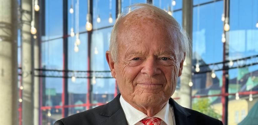 Mann I dress holder et stettglass i hånden