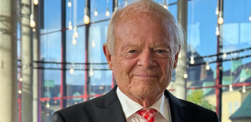 Mann I dress holder et stettglass i hånden