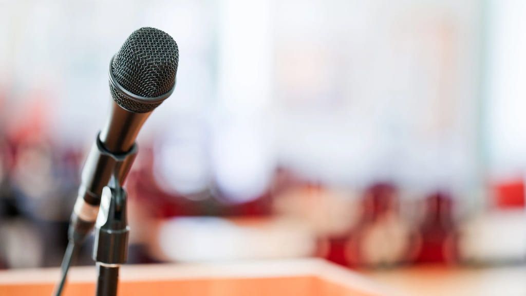 Nærbilde av en mikrofon på en scene. Bakgrunnen er uklar. 