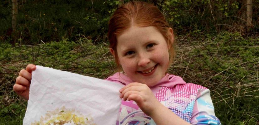 Jente på ca. 10 år holder et bildeav en gul regnbue