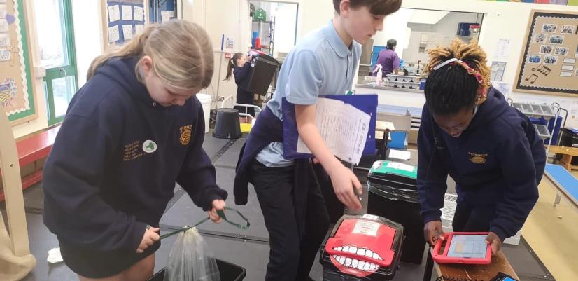 Tre barn tømmer store sorte søppelspann