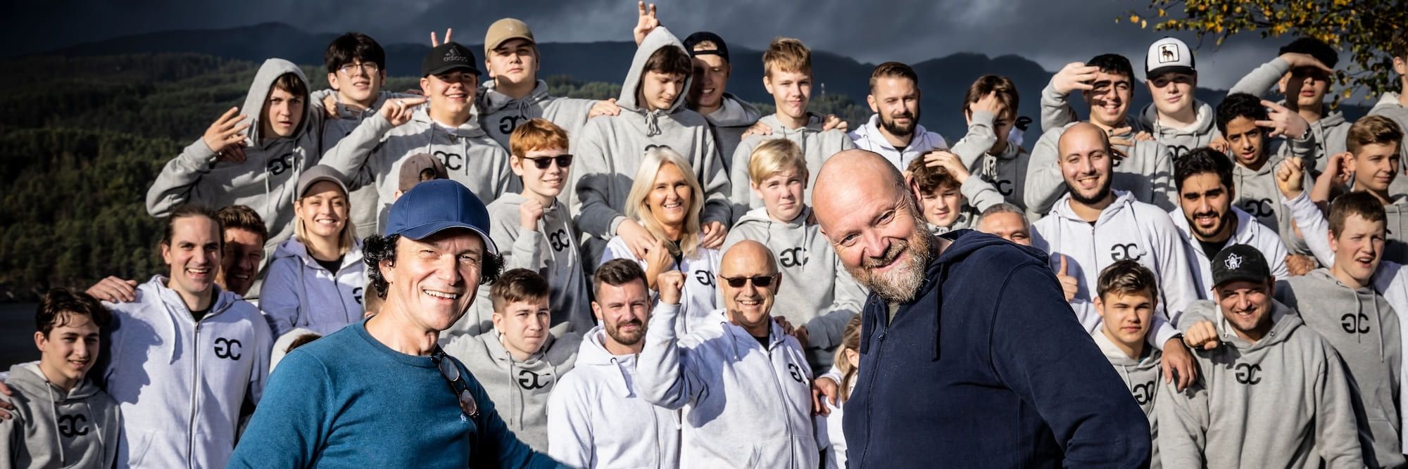 Gruppefoto av en stor gjeng med gutter, mentorer, øvrig læringsstab og filmskaperne Nils og Ronny, under læringscampen til Guttas Campus.