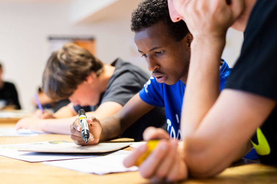 Gutter arbeider konsentrert med skolearbeid