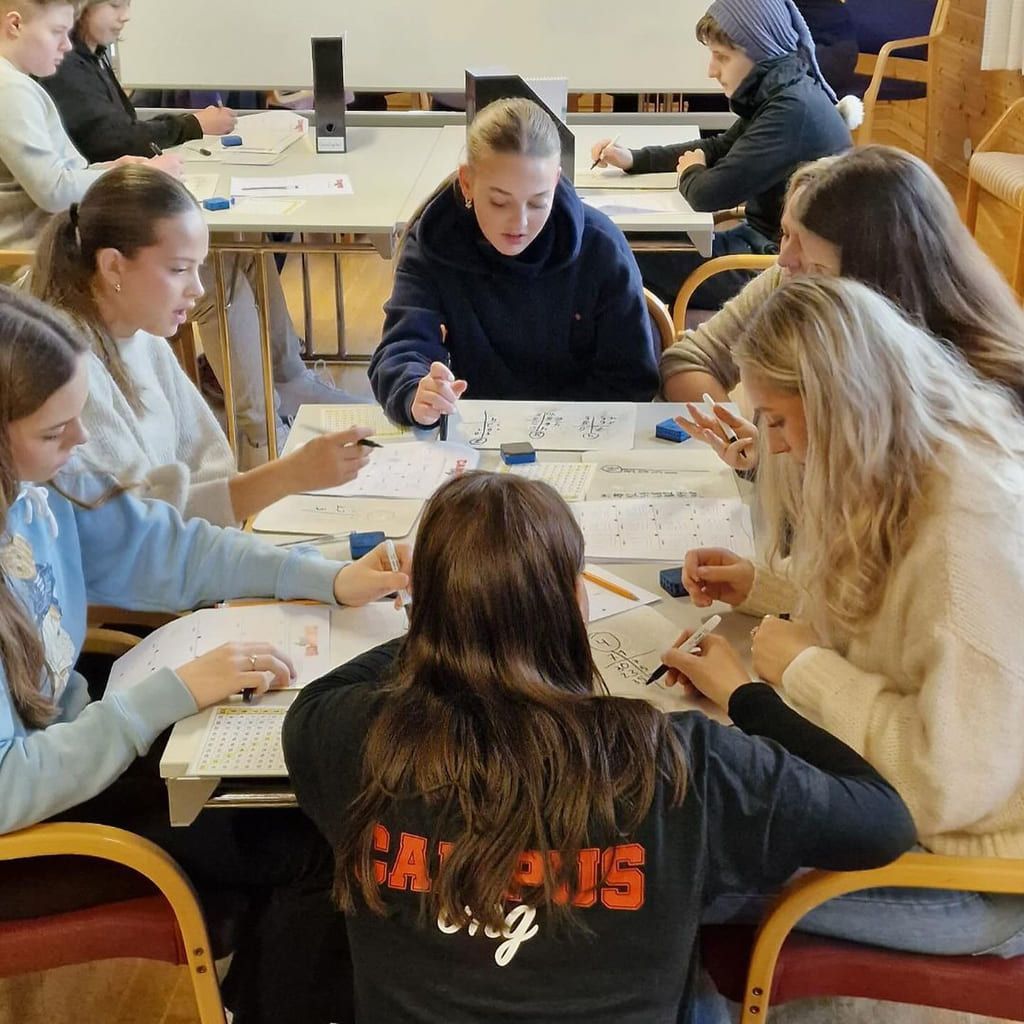 En gruppe jenter får læringsstøtte fra en lærer på Campus UNG