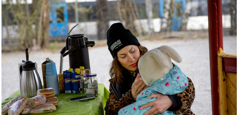 A mother feeds her daughter at Unga Station, which moved much of its activities outdoors during spring 2020 due to COVID-19.
