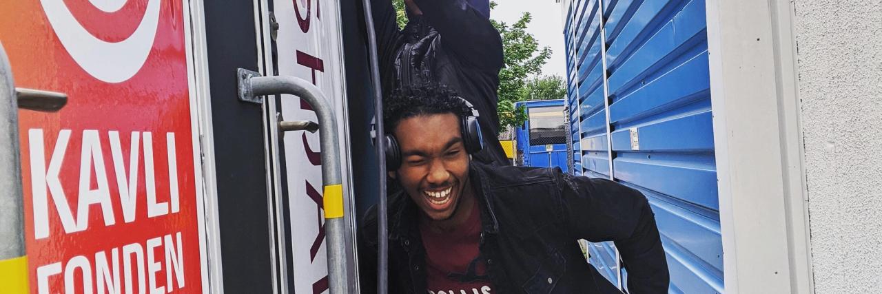 Två tonårskillar har roligt framför ”Shark Tanken”, en vagn som ungdomarna själva har renoverat och använder som mötesplats, studio och aktivitetsrum.