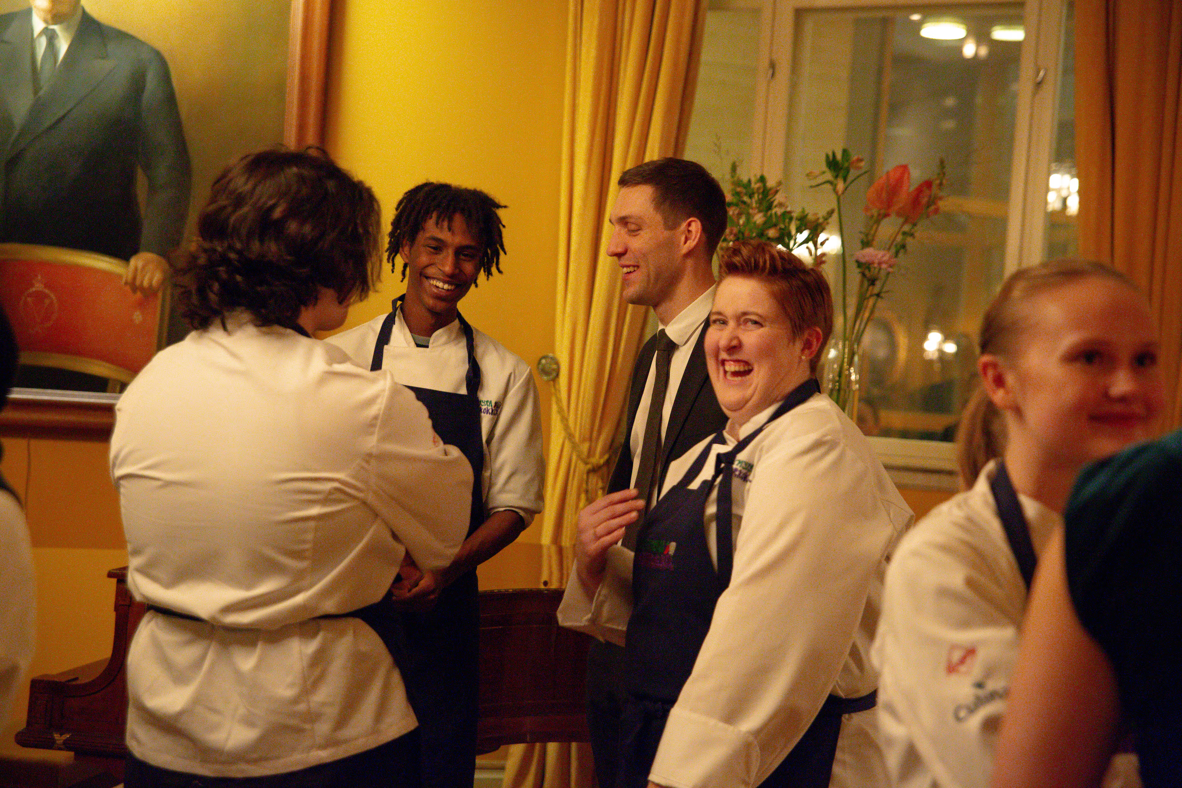 Leende unga kockar i samtal. Här är de på besök på det norska kungliga slottet, där de har lagat maten för tillfället.