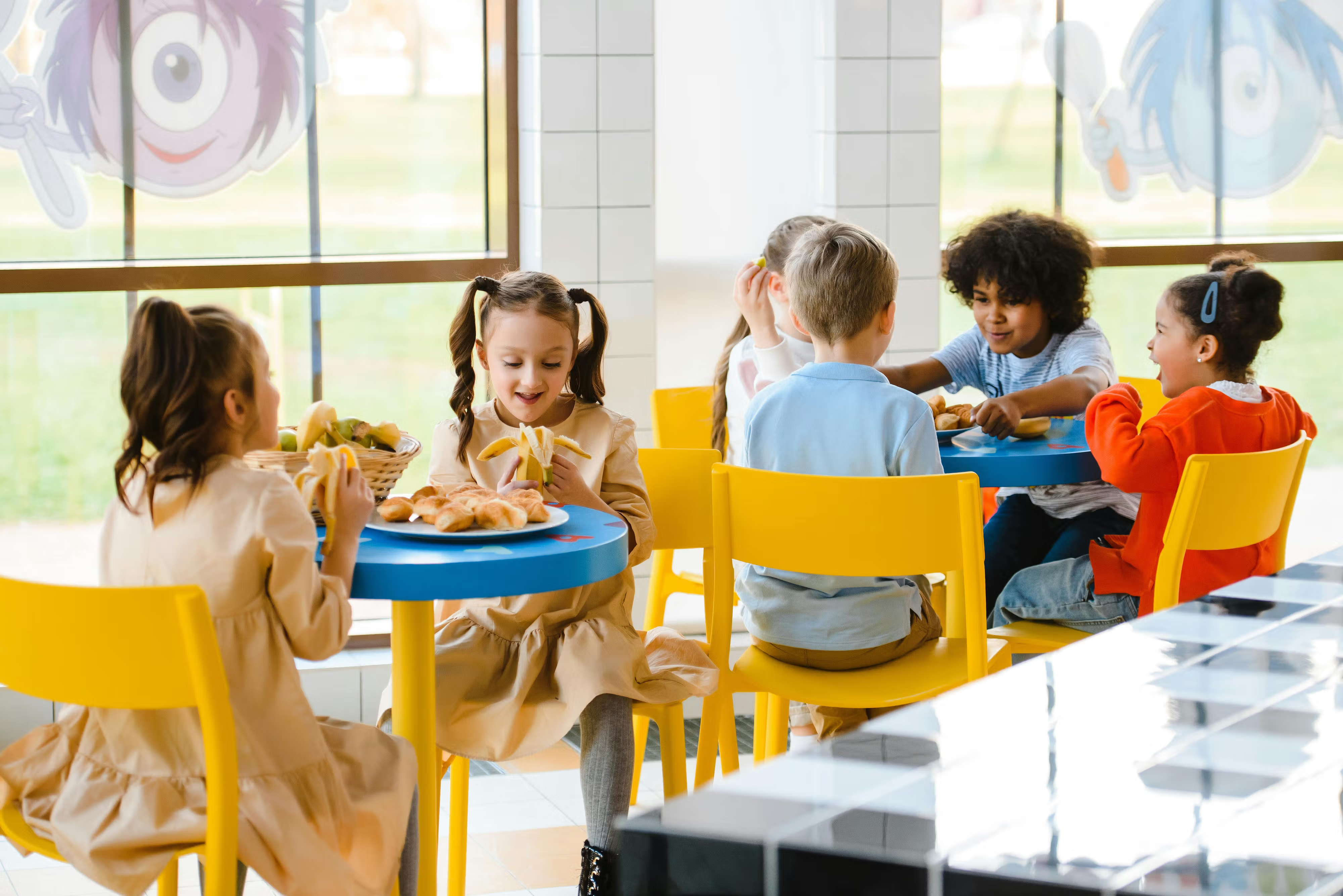Happy children eating lunch in a cafeteria