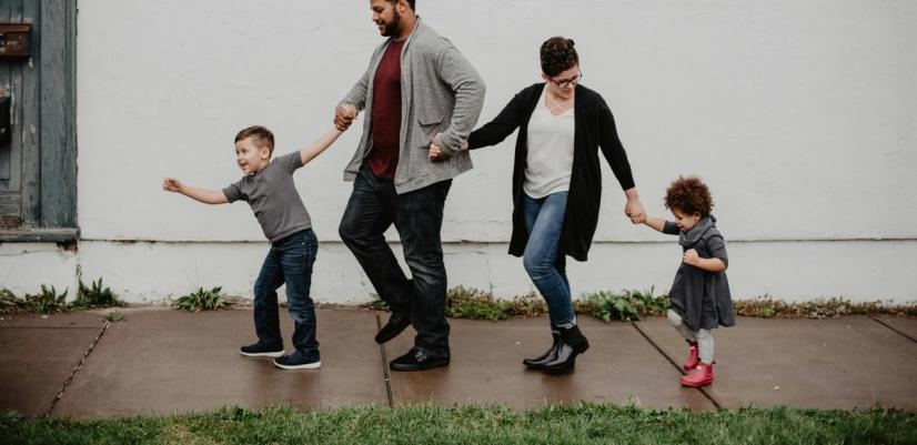 Fire personer, to voksne og to barn som alle holder hender.
