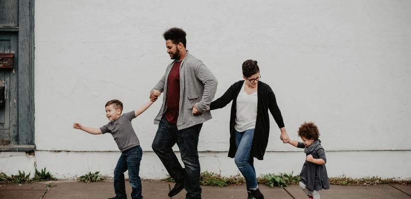 Fire personer, to voksne og to barn som alle holder hender.