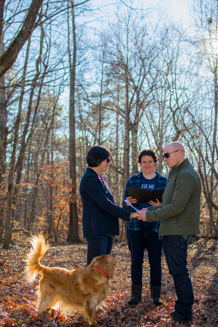 Carly marrying a couple in Duke Forest while their golden retriever watches