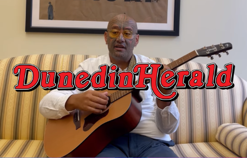 Rawiri Waititi singing with a guitar