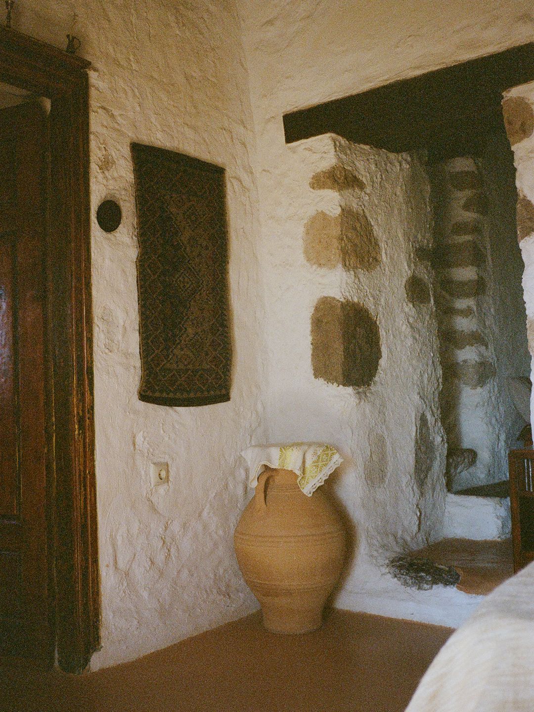 Terra cotta amphora with antique lace and hung vintage textile, Milos