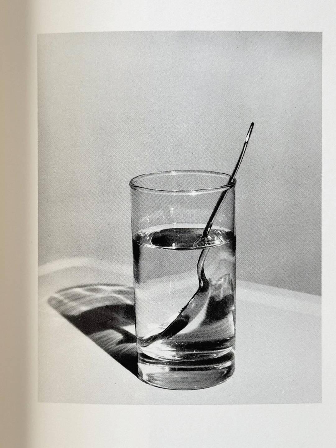 Still life of a spoon in a glass of water by Jo Ann Callis
