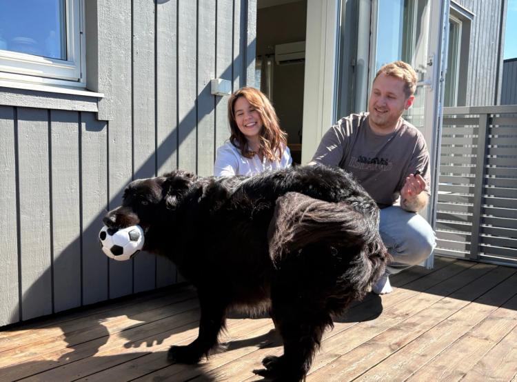Thea og Adrian leker med hunden Felix på balkongen sin.