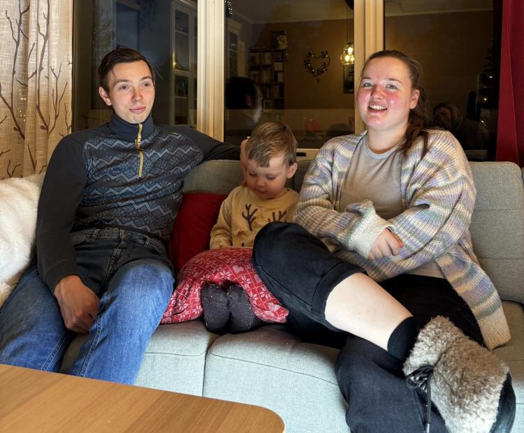 Lene Cathrine og Kenneth med barn i sofaen i stuen