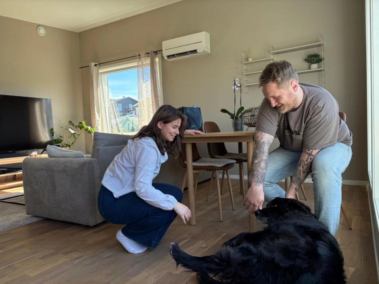 Thea og Adrian leker med hunden Felix inne i leiligheten sin. 