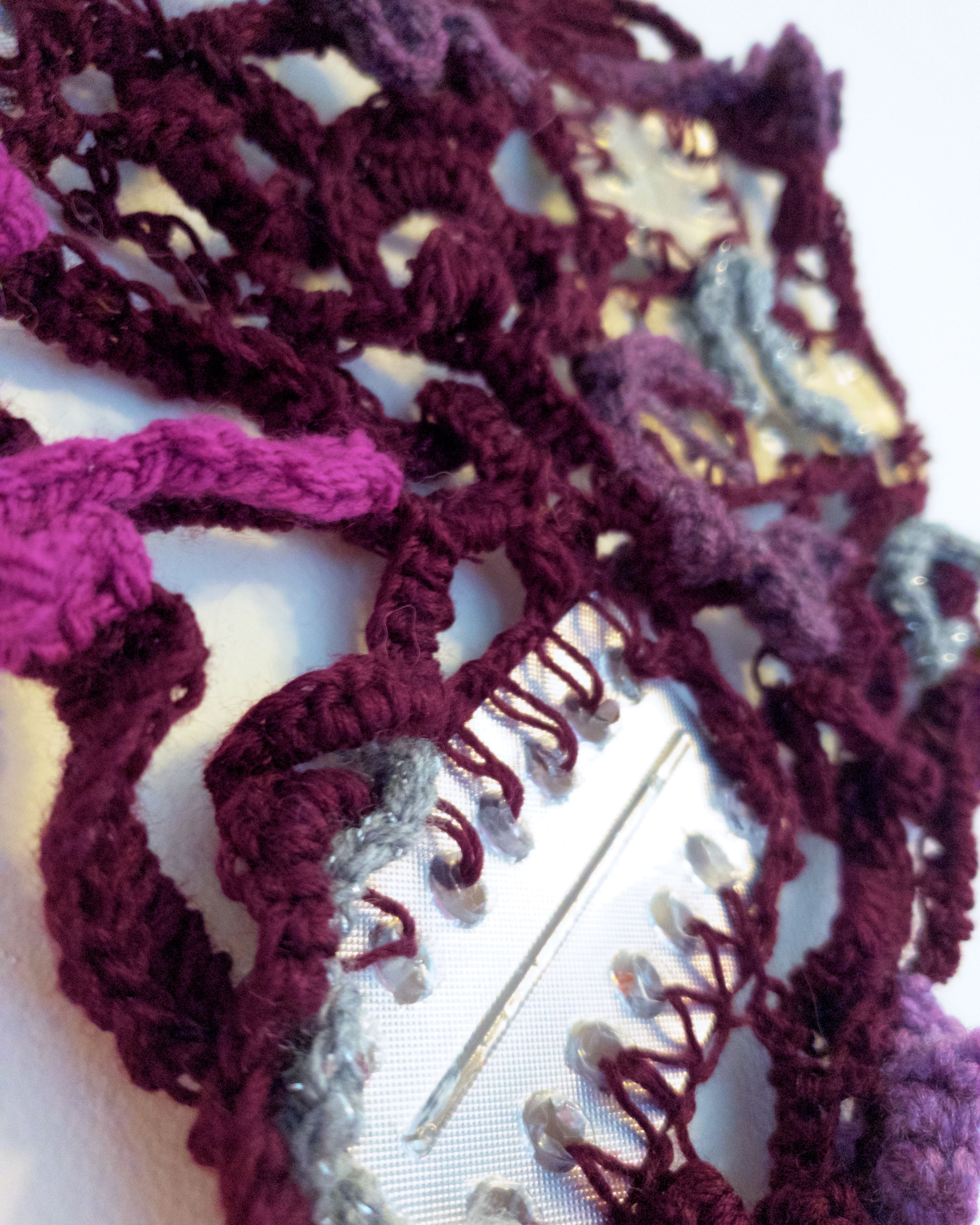 Close up of crochet sculpture with empty antidepressant plastic packaging