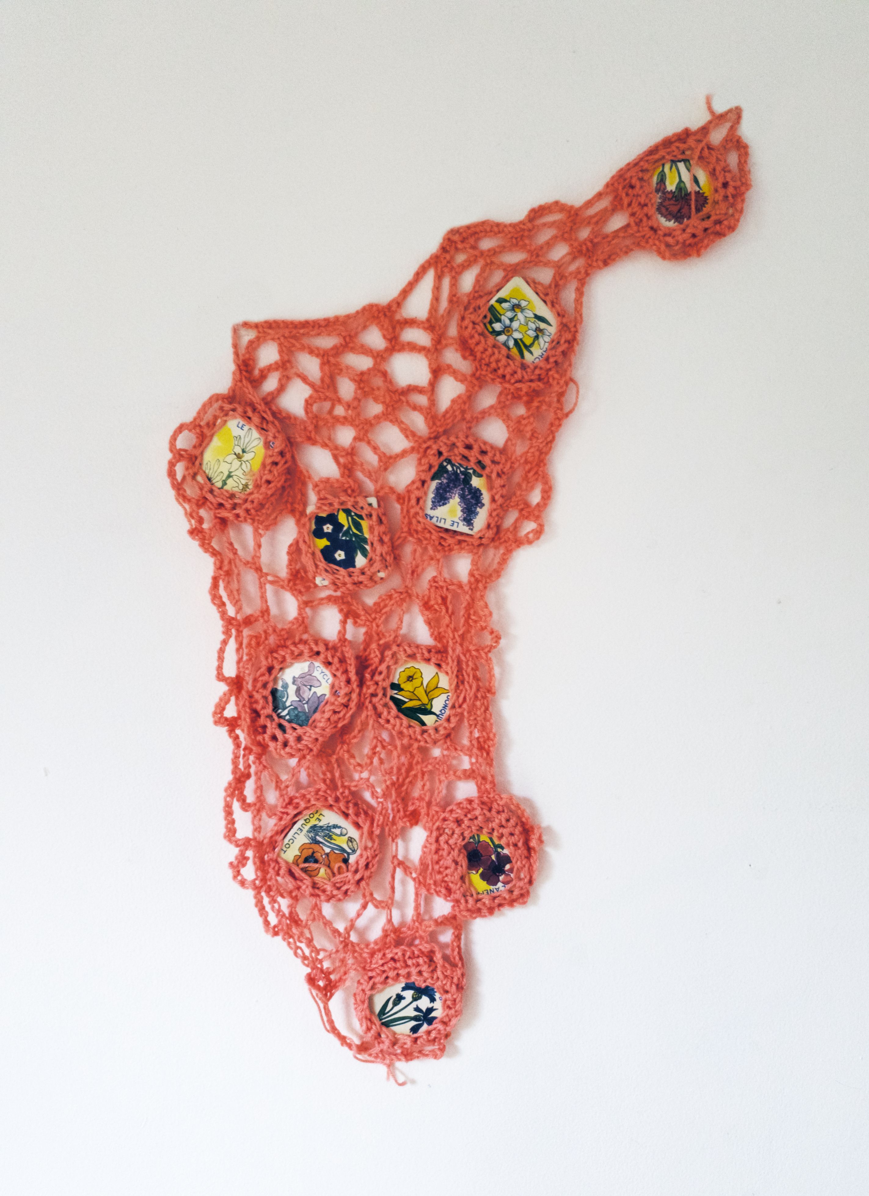 Pink crochet sculpture with pieces of a French children's game