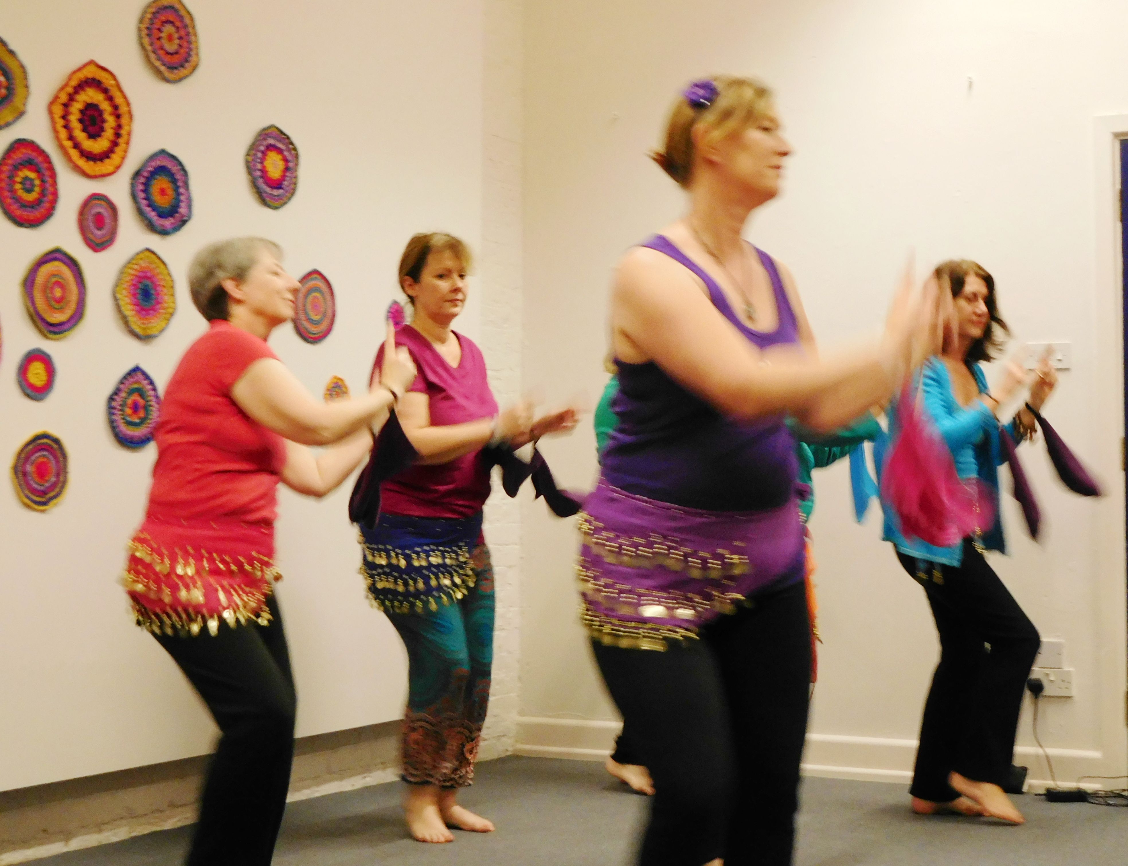 A community performance piece of people dancing in front of crochet circles