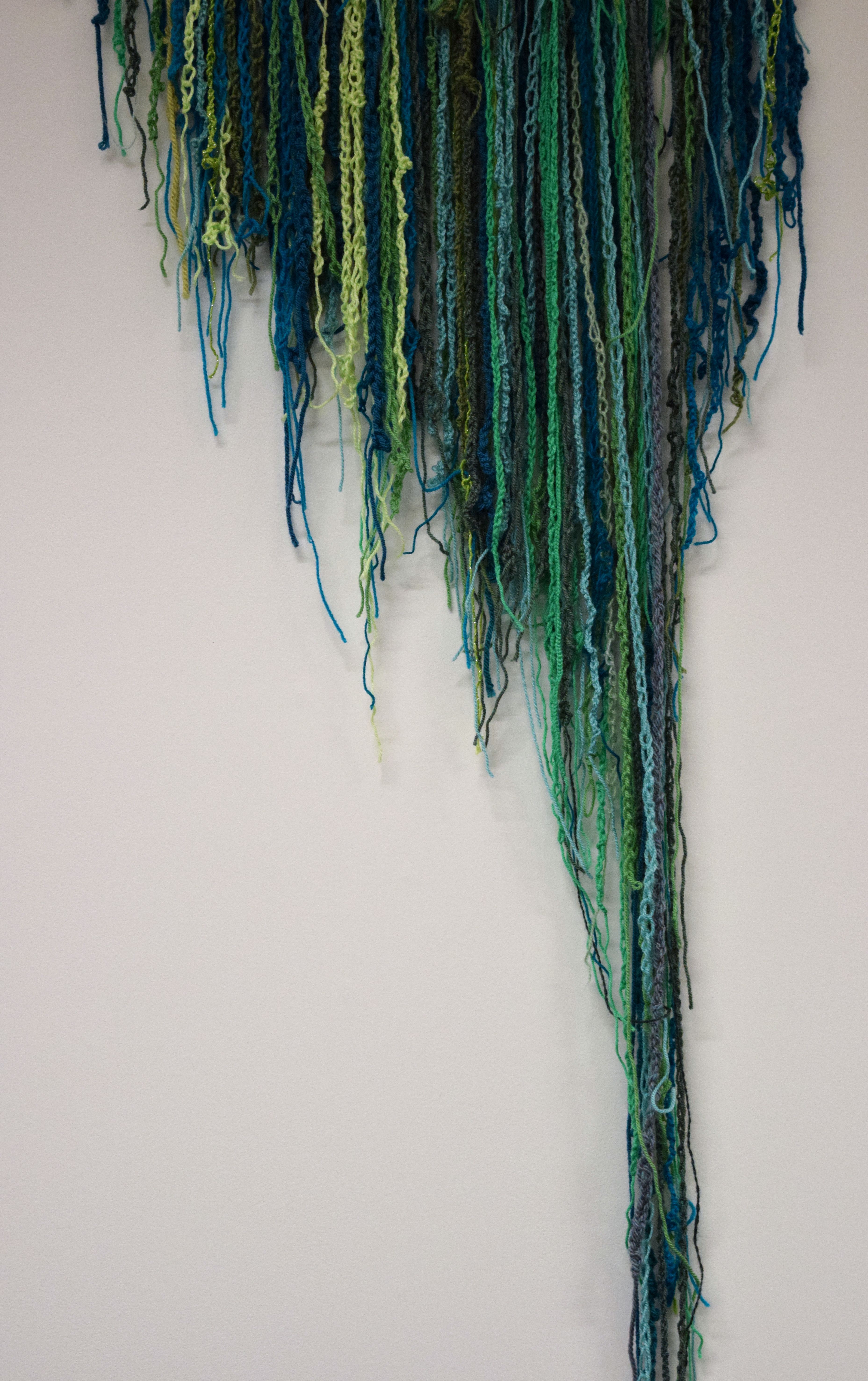 A crochet sculpture made of lots of wool chains in various shade of green