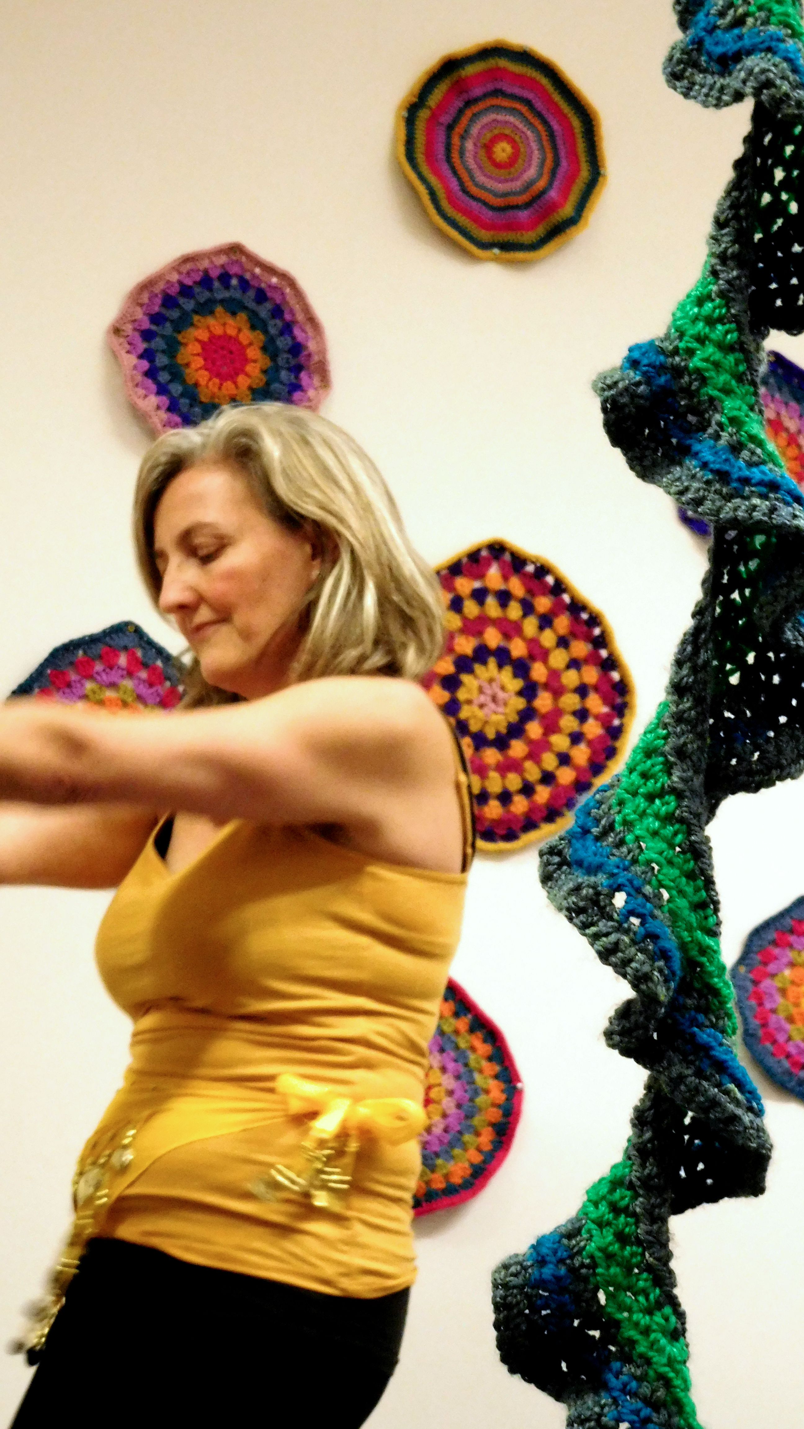 Person dancing in response to crochet installation