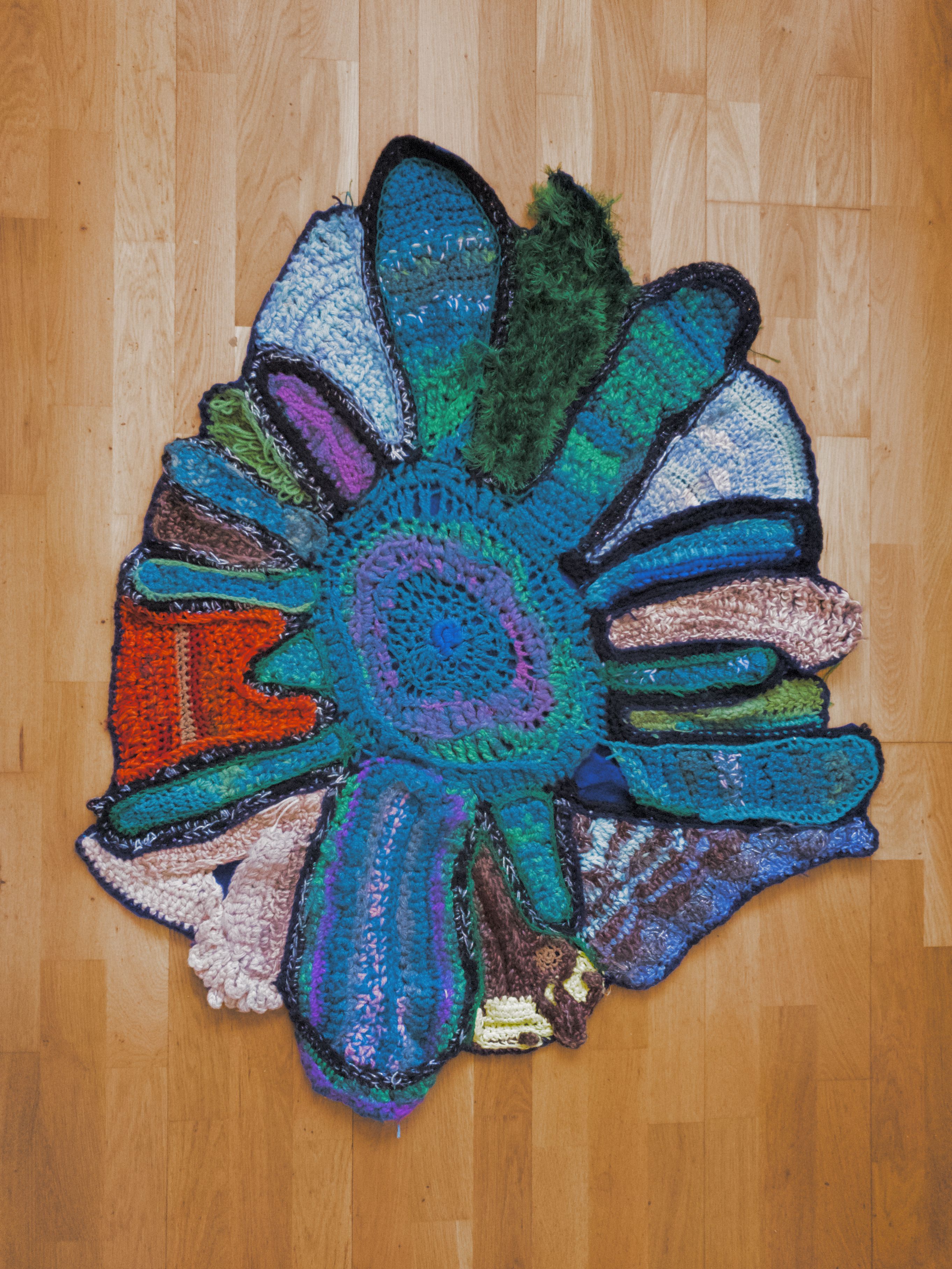 Crochet rug sculpture in green, blue and orange