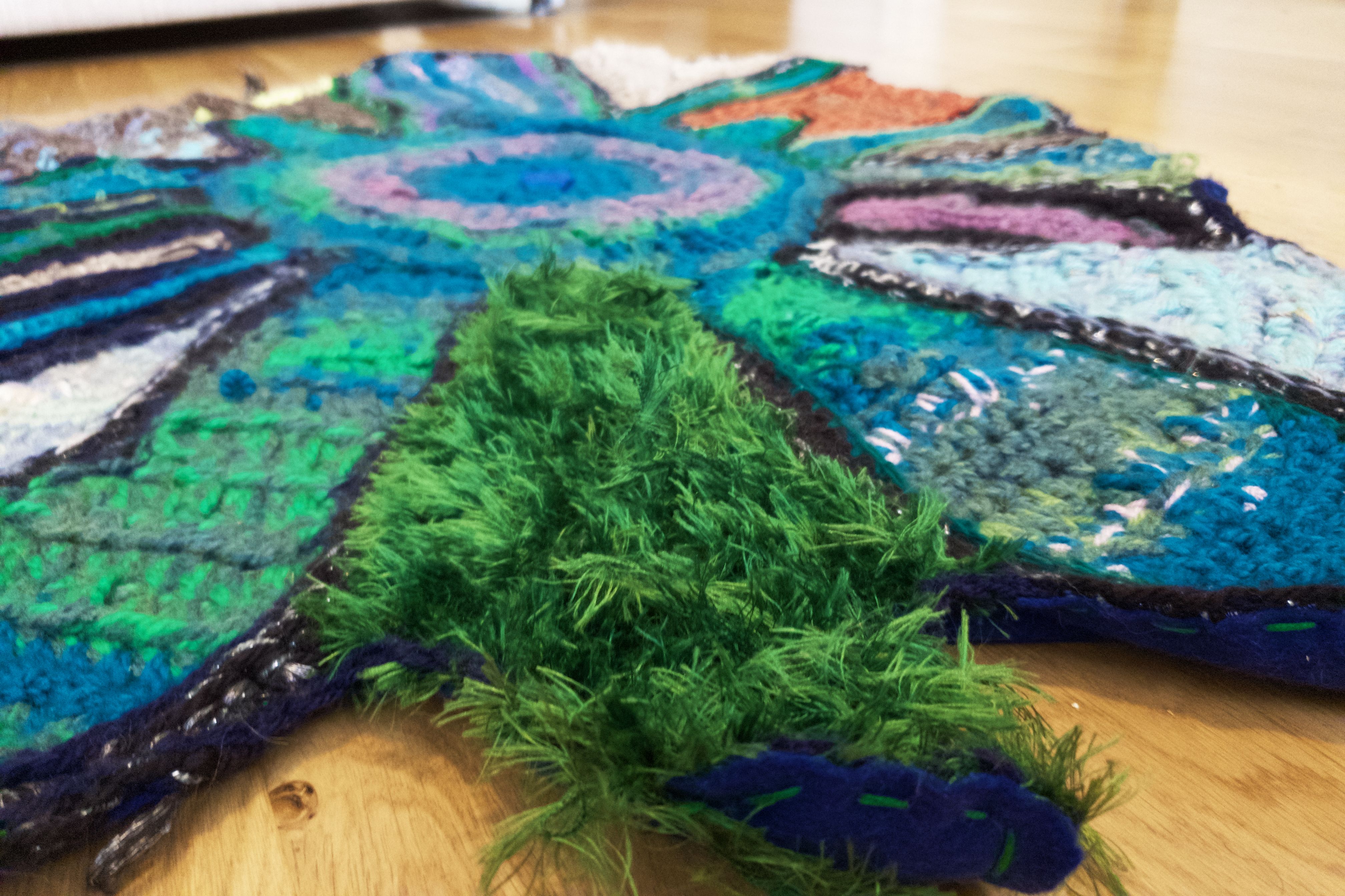 Close up of crochet rug sculpture with green grass texture