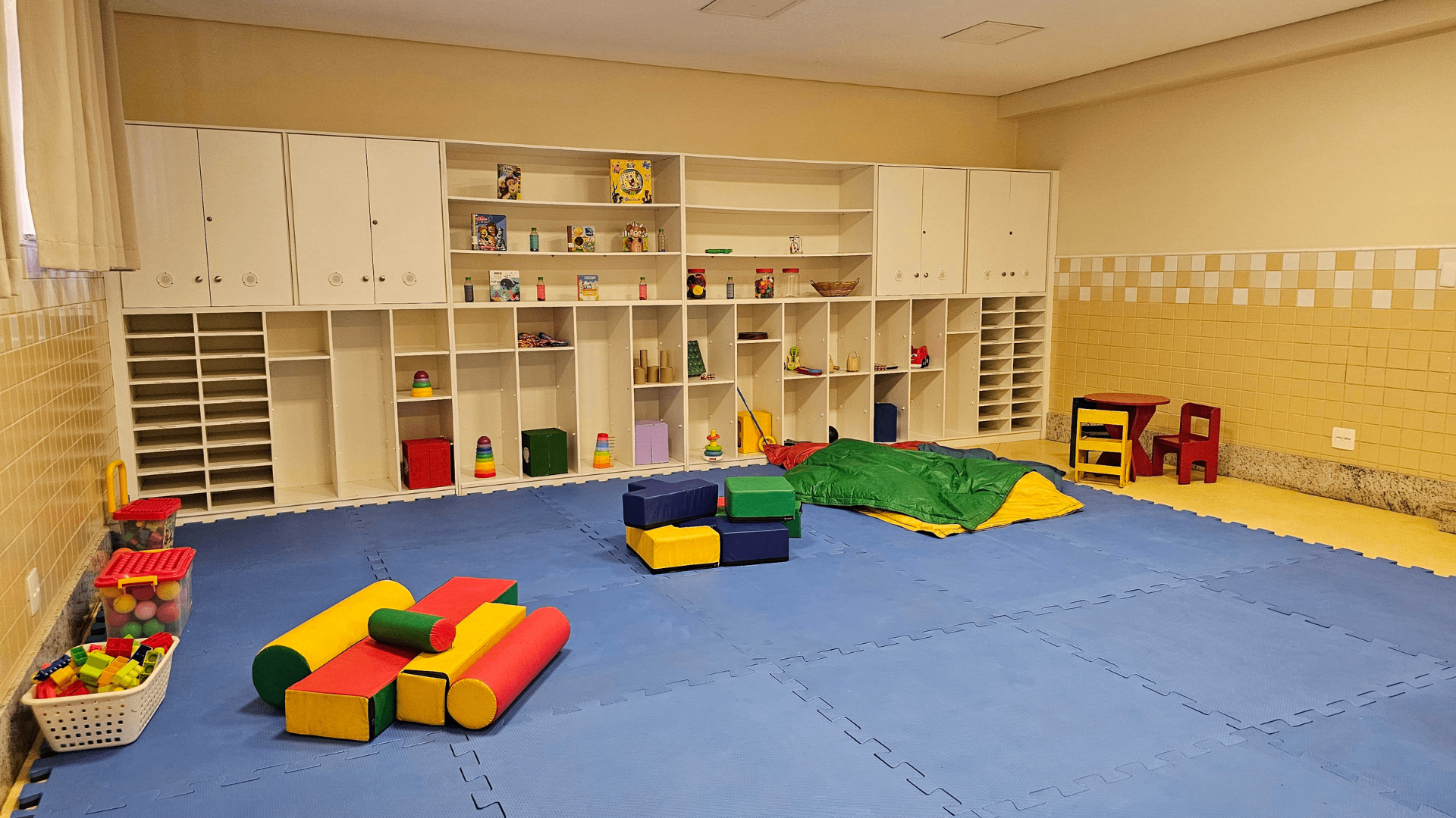 Sala da Educação Infantil com piso emborrachado, brinquedos e mobiliário adaptado