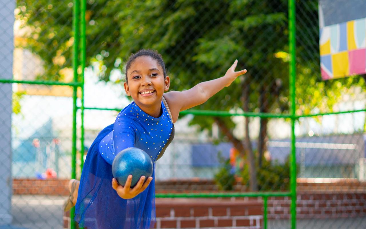 Aluna de ginástica rítmica posa com uma bola durante atividade do Coração em Movimento