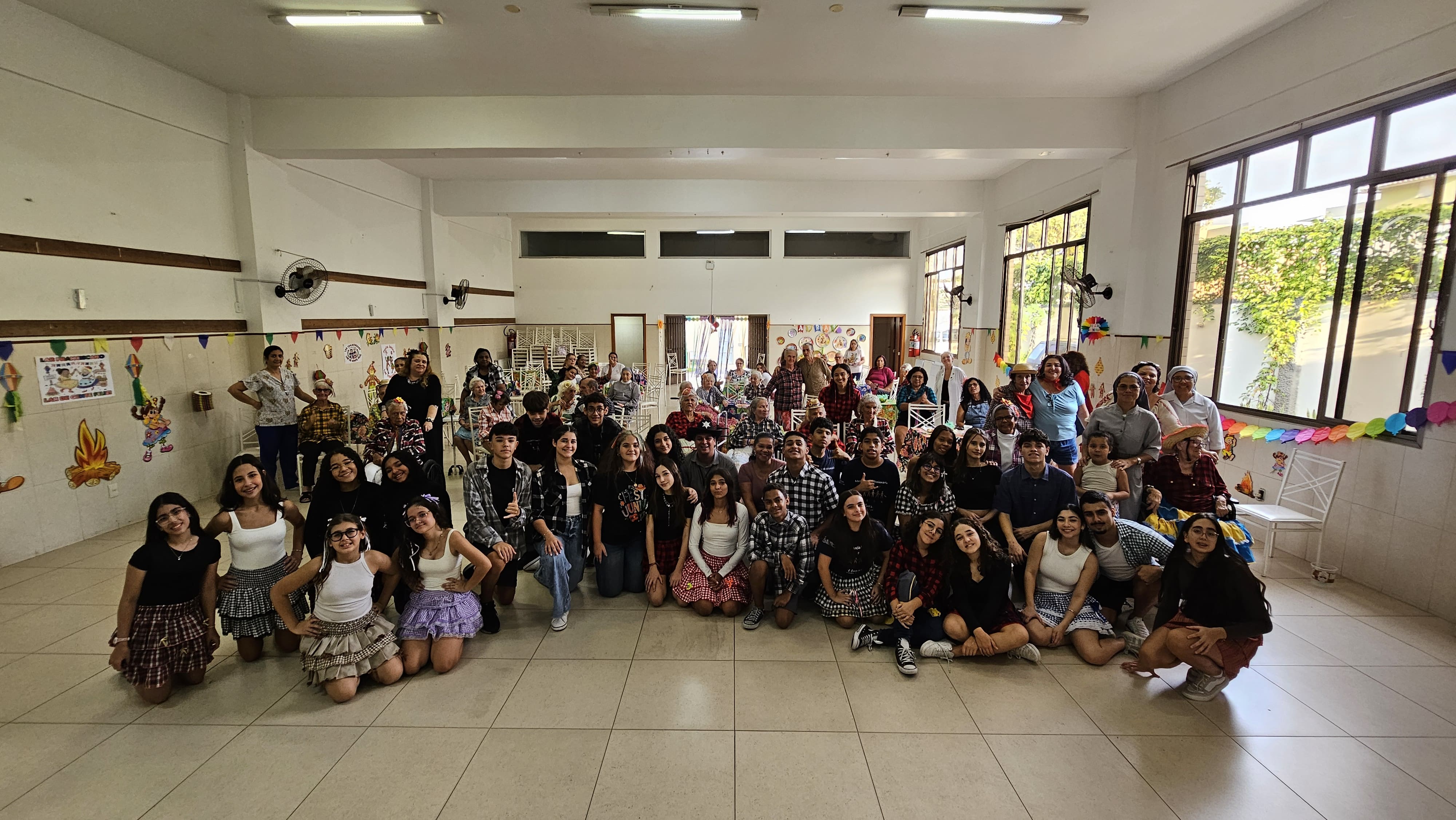 Estudantes da Adolescência Missionária e idosos do Lar Franciscano reunidos durante festa junina