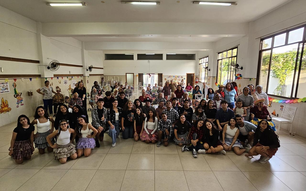 Estudantes da Adolescência Missionária e idosos do Lar Franciscano reunidos durante festa junina