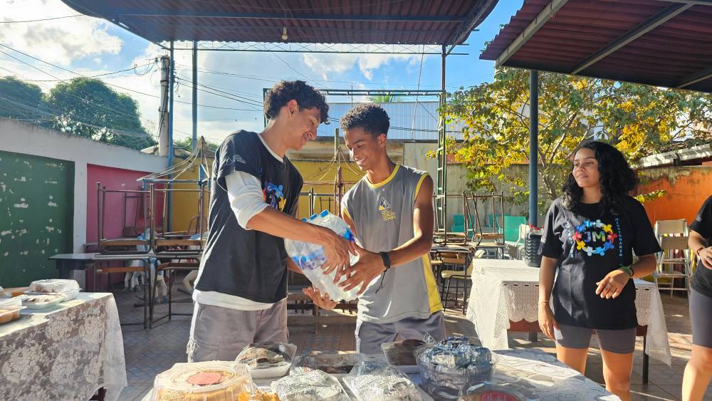 Jovens da Juventude Missionária entregam garrafas de água durante ação no Jardim Gramacho