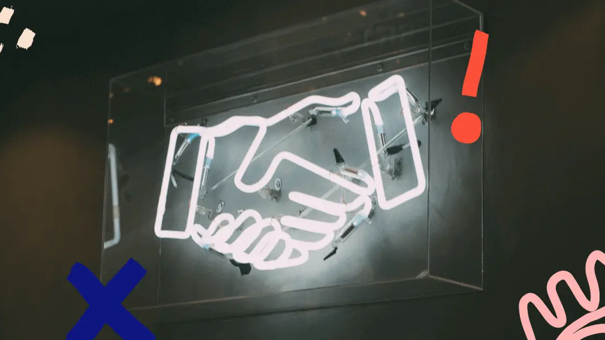 Neon sign of two hands shaking, with colorful abstract shapes on a dark background. Mood is energetic.
