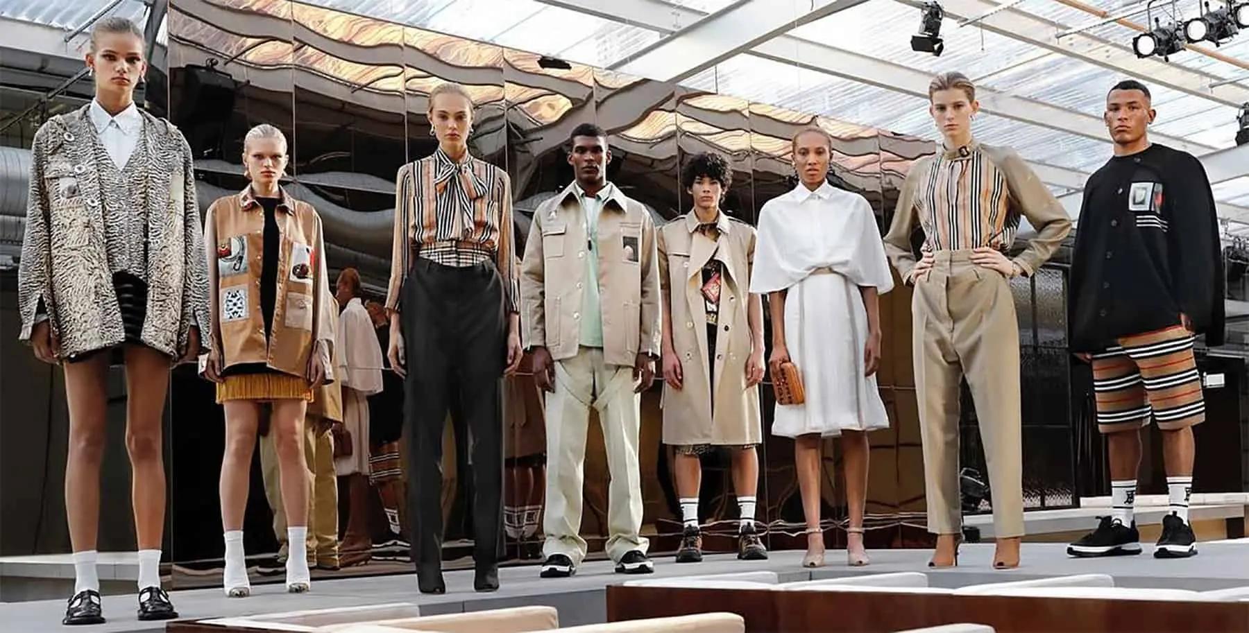 Modelos en una pasarela con gabardinas Burberry, camisas de rayas y prendas de cuadros