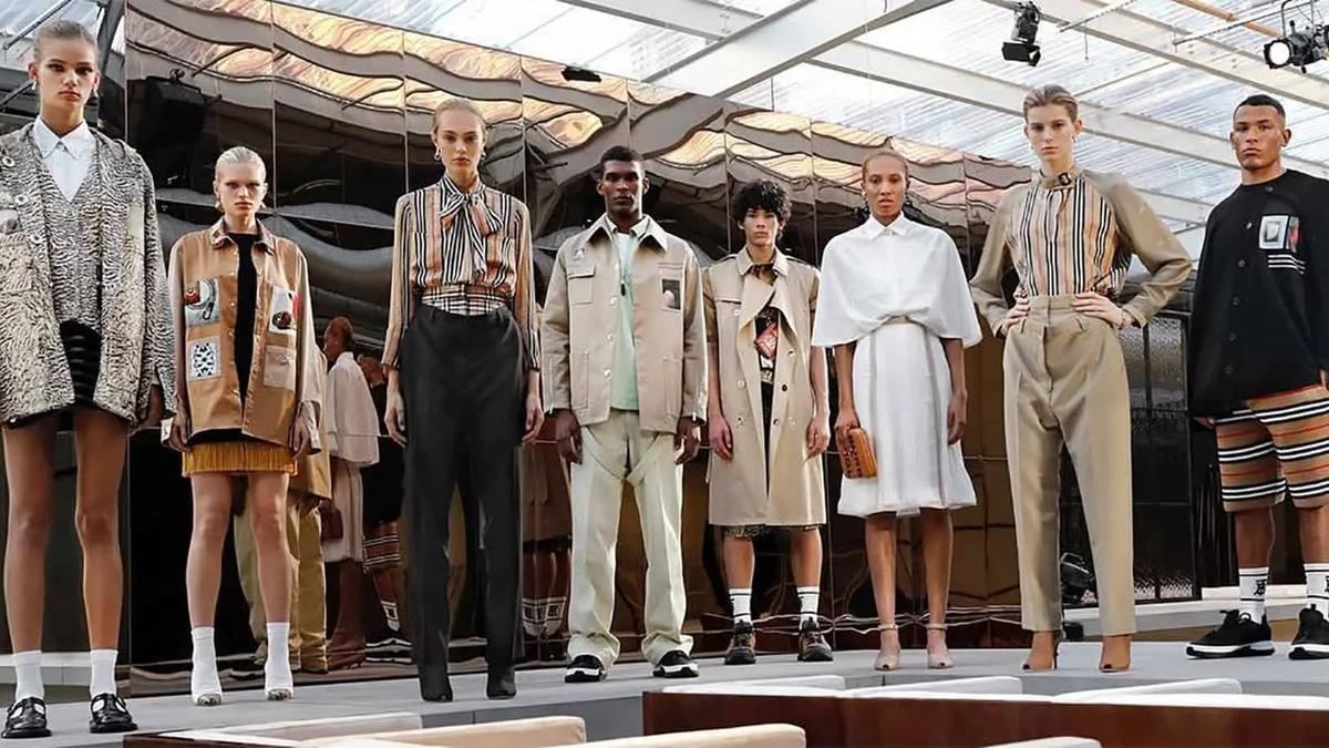 Modelos en una pasarela con gabardinas Burberry, camisas de rayas y prendas de cuadros