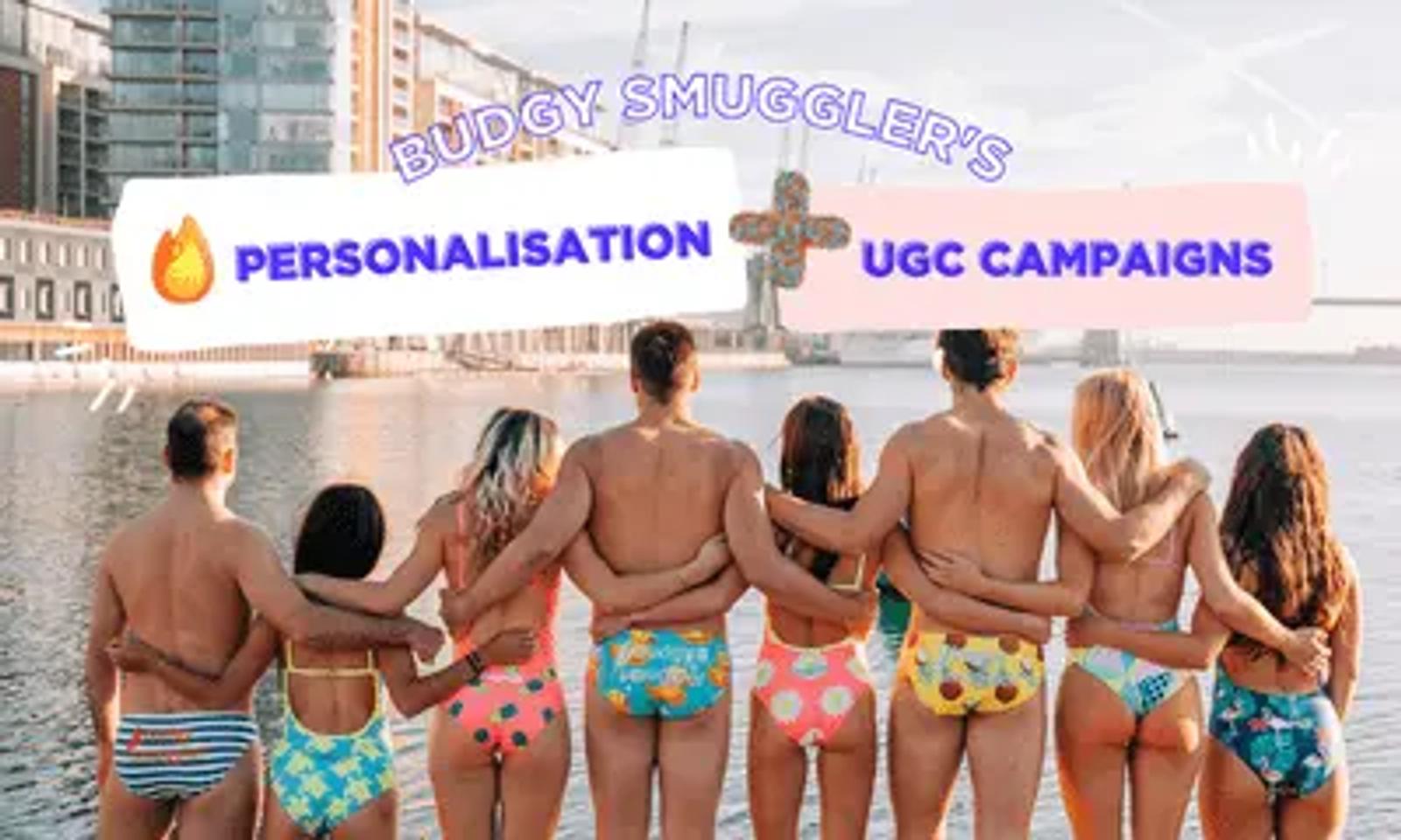 People in colourful swimwear standing arm in arm by a waterfront, with a Budgy Smuggler campaign banner overlay.