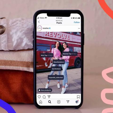 Pantalla de teléfono con una publicación de Instagram y etiquetas de producto sobre dos personas junto a un autobús