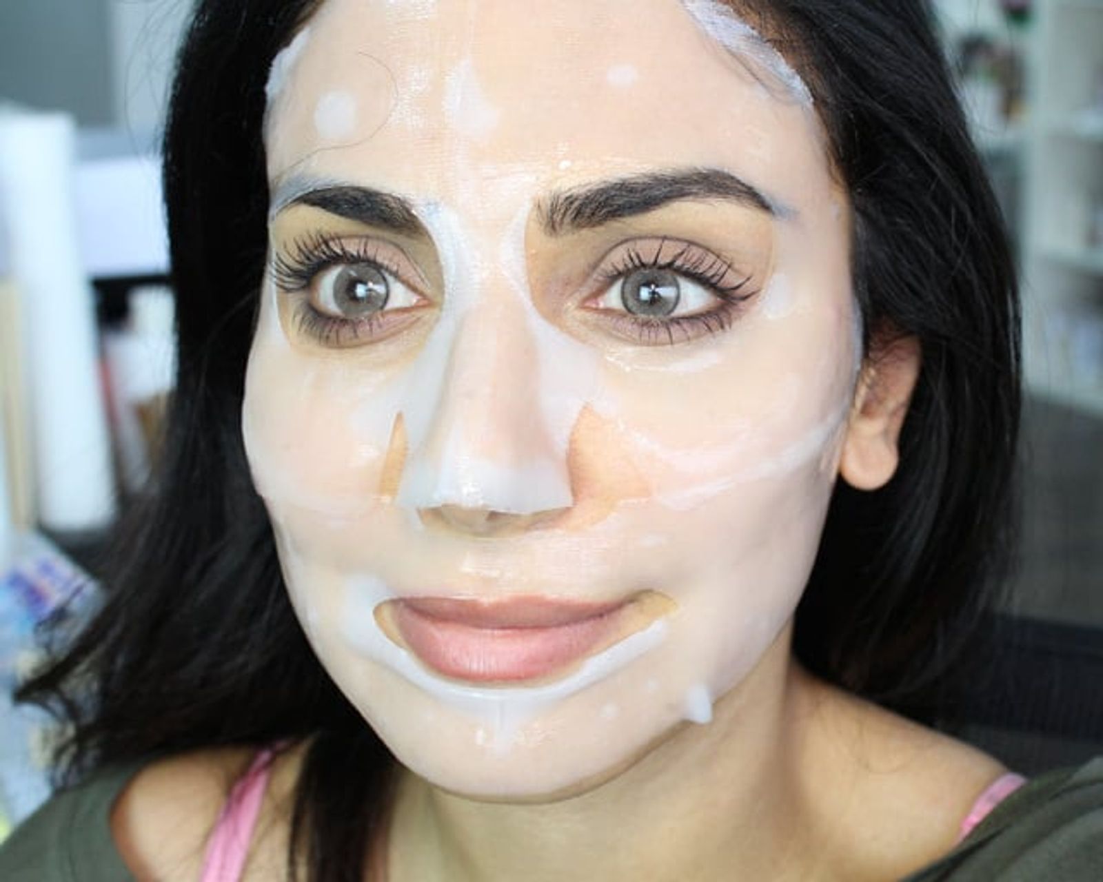 Mujer de cabello oscuro con una mascarilla facial de tela, mirando a la cámara en una selfie.