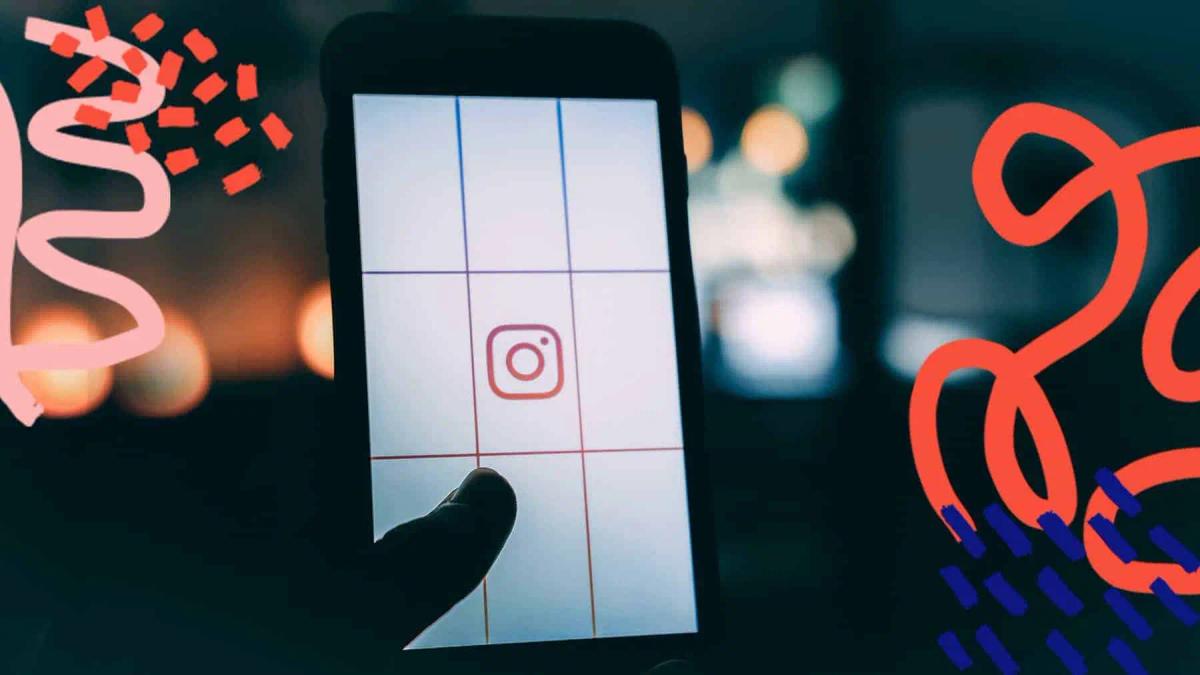 A hand holding a phone showing the Instagram logo on a grid layout screen