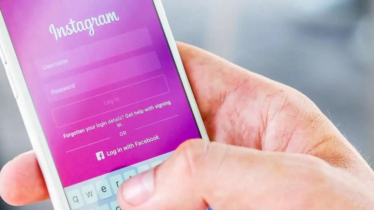 Una mano sostiene un teléfono con la pantalla de inicio de sesión de Instagram, con campos de usuario y contraseña
